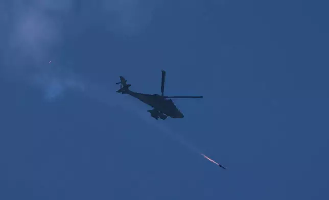 An Israeli Apache helicopter fires a missile towards southern Lebanon as seen form northern Israel, Monday, March 23, 2026. (AP Photo/Ariel Schalit)