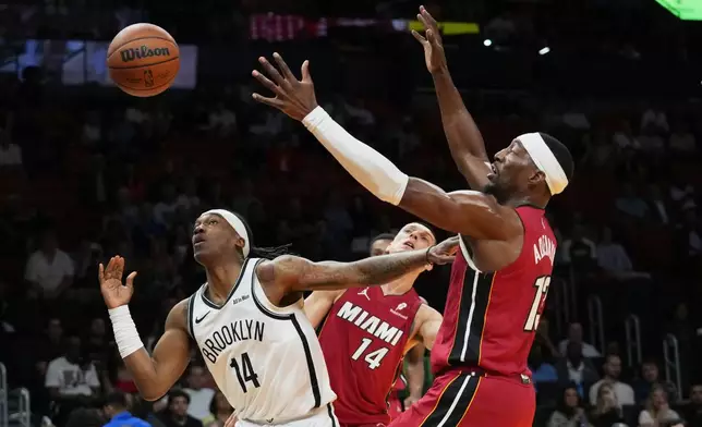 Brooklyn Nets guard Terance Mann (14) loses control of the ball as Miami Heat center Bam Adebayo (13) defends during the first half of an NBA basketball game, Thursday, March 5, 2026, in Miami. (AP Photo/Lynne Sladky)