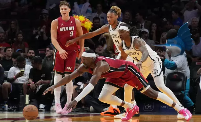 Miami Heat center Bam Adebayo, front, goes for a loose ball against Brooklyn Nets forward Noah Clowney (21) and guard Terance Mann (14) during the first half of an NBA basketball game, Thursday, March 5, 2026, in Miami. (AP Photo/Lynne Sladky)
