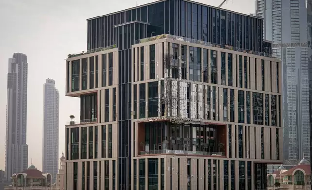 Facade of a building at Dubai's financial district is seen partially damaged which, according to the authorities was caused by falling debris after a successful interception, United Arab Emirates, Friday, March 13, 2026. (AP Photo/Altaf Qadri)