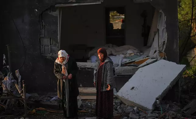 Residents inspect a house destroyed by an Iranian missile strike in Zarzir, northern Israel, Friday, March 13, 2026. (AP Photo/Ariel Schalit)