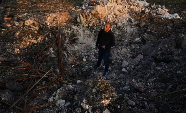 A man looks a the site struck by an Iranian missile in Zarzir, northern Israel, Friday, March 13, 2026. (AP Photo/Ariel Schalit)