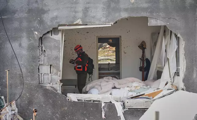 Officers from Israel's Home Front Command inspect a house destroyed by an Iranian missile strike in Zarzir, northern Israel, Friday, March 13, 2026. (AP Photo/Ariel Schalit)