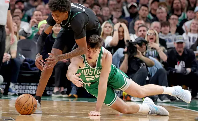 Minnesota Timberwolves forward Jaden McDaniels, left, and Boston Celtics forward Hugo González, right, trip each other up chasing the ball during the first half of an NBA basketball game, Sunday, March 22, 2026, in Boston. (AP Photo/Mark Stockwell)