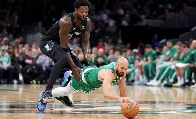 Boston Celtics guard Derrick White, right, dives for a loose ball in front of Minnesota Timberwolves forward Julius Randle, left, during the first half of an NBA basketball game, Sunday, March 22, 2026, in Boston. (AP Photo/Mark Stockwell)