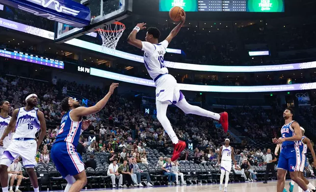 Utah Jazz forward Ace Bailey (19) goes up to dunk over Philadelphia 76ers forward Trendon Watford, third from left, during the second half of an NBA basketball game, Saturday, March 21, 2026, in Salt Lake City. (AP Photo/Anna Fuder)