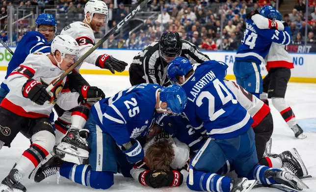 The Toronto Maple Leafs and the Ottawa Senators brawl on the ice during third-period NHL hockey game action in Toronto, Saturday, Feb 28, 2026. (Frank Gunn/The Canadian Press via AP)