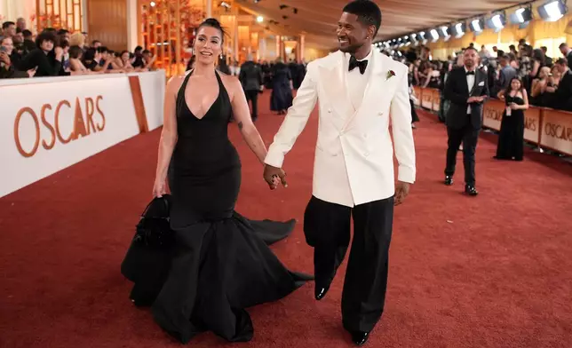 Jenn Goicoechea, left, and Usher arrives at the Oscars on Sunday, March 15, 2026, at the Dolby Theatre in Los Angeles. (AP Photo/John Locher)