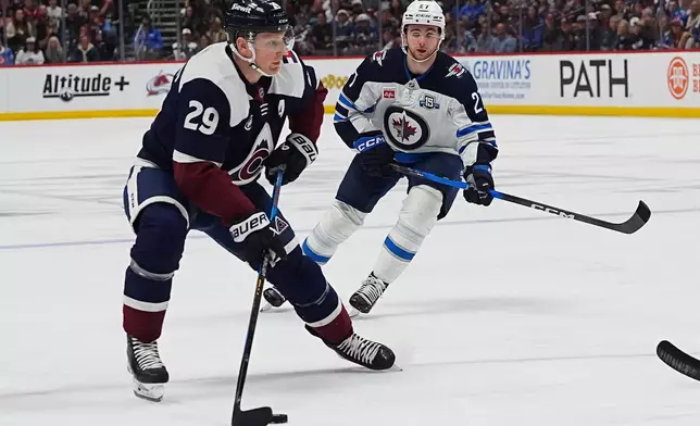 Colorado Avalanche center Nathan MacKinnon (29) drives past Winnipeg Jets right wing Isak Rosen, right, in the first period of an NHL hockey game Saturday, March 28, 2026, in Denver. (AP Photo/David Zalubowski)