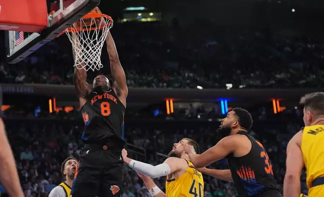 New York Knicks' Og Anunoby (8) dunks the ball in front of Indiana Pacers' Ivica Zubac (40) and teammate Karl-Anthony Towns (32) during the second half of an NBA basketball game Tuesday, March 17, 2026, in New York. (AP Photo/Frank Franklin II)