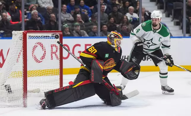 Vancouver Canucks goalie Nikita Tolopilo (60) allows a goal to Dallas Stars' Lian Bichsel, not seen, as Jamie Benn (14) watches during the second period of an NHL hockey game, in Vancouver, on Monday, March 2, 2026. (Darryl Dyck/The Canadian Press via AP)