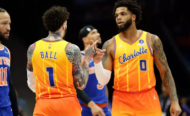 Charlotte Hornets forward Miles Bridges (0) celebrates with guard LaMelo Ball (1) after a basket against the New York Knicks during the first half of an NBA basketball game in Charlotte, N.C., Thursday, March 26, 2026. (AP Photo/Nell Redmond)