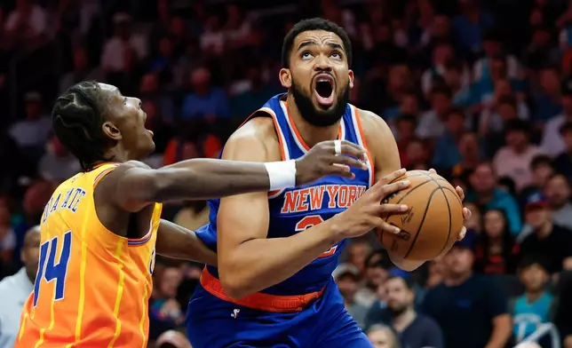 New York Knicks center Karl-Anthony Towns, right, prepares to shoot against Charlotte Hornets forward Moussa Diabate during the first half of an NBA basketball game in Charlotte, N.C., Thursday, March 26, 2026. (AP Photo/Nell Redmond)