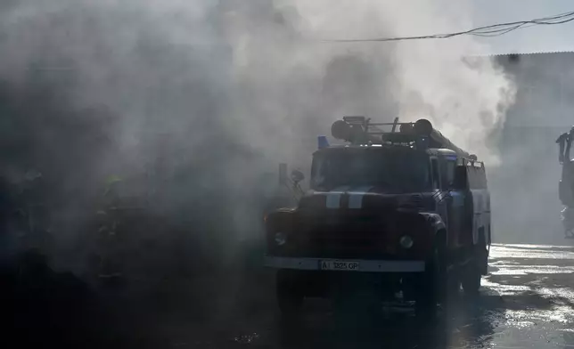 Firefighters put out the fire at a residential neighbourhood following a Russia missile and drone attack, in Brovary, close to Kyiv, Ukraine, Saturday, March 14, 2026. (AP Photo/Efrem Lukatsky)