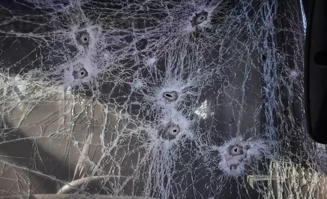 Shrapnel holes cover the glass of a damaged bus near railway workshops, following a Russia missile and drone attack, in Brovary close to Kyiv, Ukraine, Saturday, March 14, 2026. (AP Photo/Efrem Lukatsky)