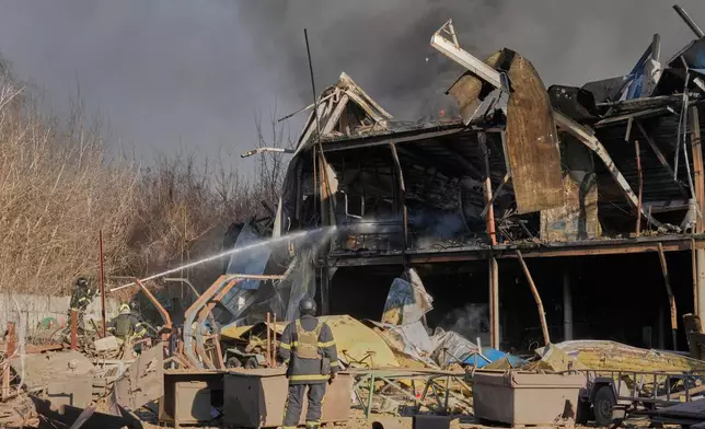 Firefighters put out the fire at railway workshops following a Russia missile and drone attack, in Brovary, close to Kyiv, Ukraine, Saturday, March 14, 2026. (AP Photo/Efrem Lukatsky)