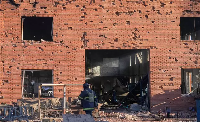 Shrapnel holes cover the wall of the damaged railway workshops, following a Russia missile and drone attack, in Brovary close to Kyiv, Ukraine, Saturday, March 14, 2026. (AP Photo/Efrem Lukatsky)