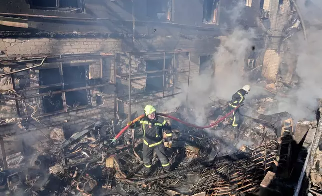Firefighters put out the fire at a residential neighbourhood following a Russia missile and drone attack, in Brovary, close to Kyiv, Ukraine, Saturday, March 14, 2026. (AP Photo/Efrem Lukatsky)