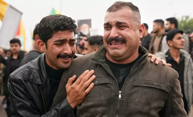 Relatives grieve in Baghdad, Iraq, Tuesday, March 24, 2026, during a funeral of members of the Popular Mobilization Forces who were killed in a U.S. airstrike in Anbar, Iraq. (AP Photo/Hadi Mizban)