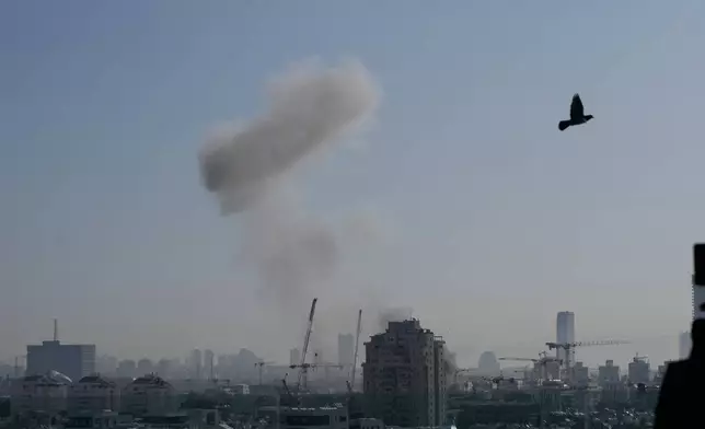 Smoke billows following an Iranian missile strike in Tel Aviv, Israel, Tuesday, March 24, 2026. (AP Photo/Ohad Zwigenberg)