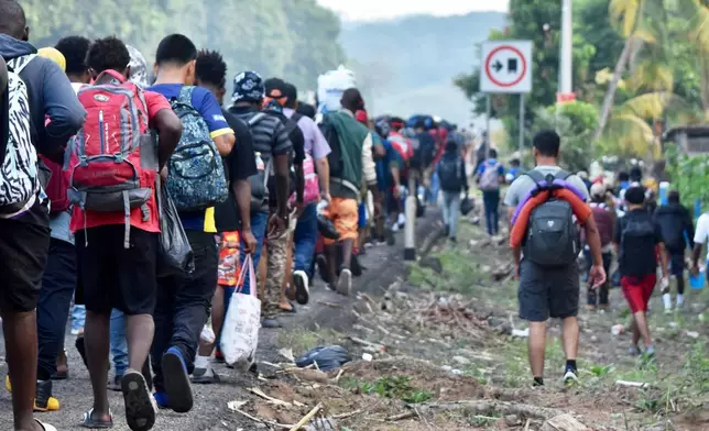 Migrants walk on the highway through the municipality of Huehuetan, Chiapas state, Mexico, Wednesday, March 25, 2026, after leaving Tapachula the previous night. (AP Photo/Edgar H. Clemente)