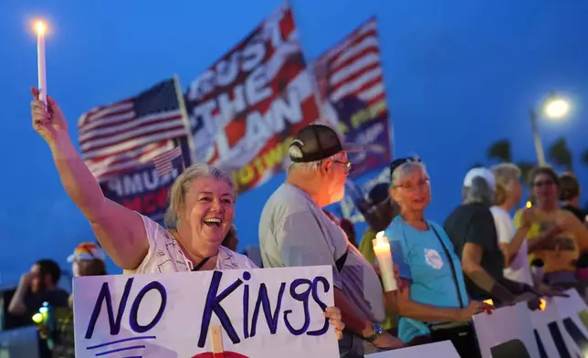 FILE - Dee Cahill of Margate, Fla., holds a "No Kings" sign as she participates in a pro-democracy, anti-Trump protest outside Trump's Mar-a-Lago estate in Palm Beach, Fla., as part of the "Good Trouble Lives On" national day of action, July 17, 2025. (AP Photo/Rebecca Blackwell, File)