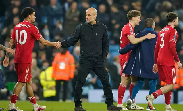 Nottingham Forest's Morgan Gibbs-White and Manchester City's head coach Pep Guardiola shake hands at the end of the English Premier League soccer match between Manchester City and Nottingham Forest in Manchester, England, Wednesday, March 4, 2026. (AP Photo/Dave Thompson)
