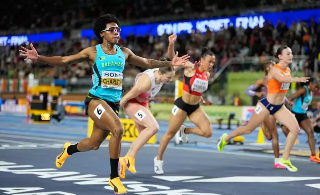 Devynne Charlton, of Bahamas, left, crosses the finish line to win the gold medal in the women's 60 meters hurdles final at the World Athletics Indoor Championships in Torun, Poland, Sunday, March 22, 2026. (AP Photo/Matthias Schrader)