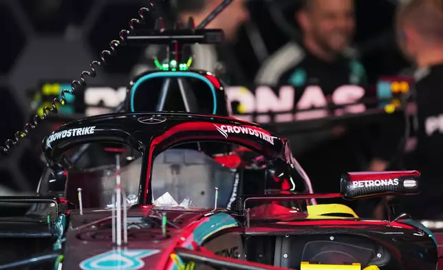 Mercedes driver George Russell of Britain's car is seen in the garage as mechanics talk nearby in Suzuka, central Japan, Thursday, March 26, 2026, ahead of Sunday's Japanese Formula One Grand Prix race. (AP Photo/Hiro Komae)