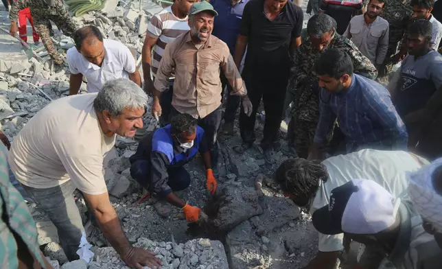 Rescue workers and residents search through the rubble in the aftermath of a strike on a girls' elementary school in Minab, Iran, Saturday, Feb. 28, 2026. (Abbas Zakeri/Mehr News Agency via AP)