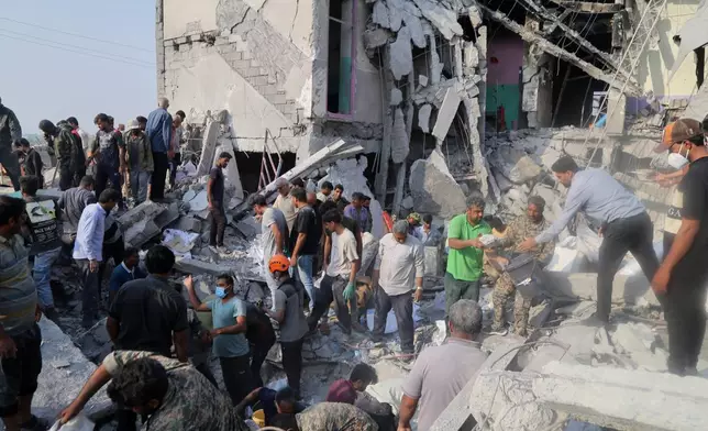 Rescue workers and residents search through the rubble in the aftermath of a strike on a girls' elementary school in Minab, Iran, Saturday, Feb. 28, 2026. (Abbas Zakeri/Mehr News Agency via AP)