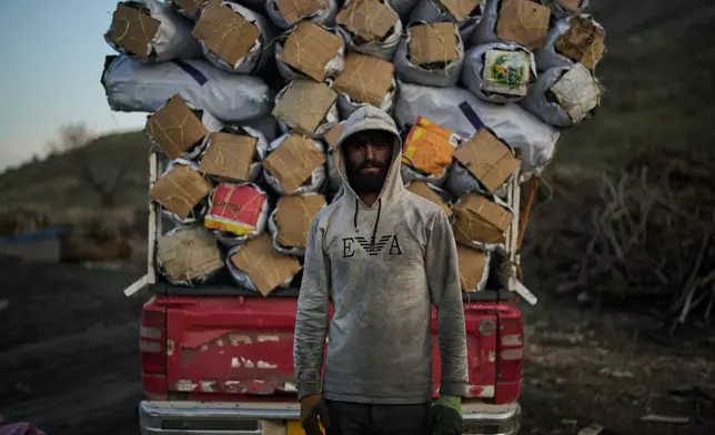 Zana, 22, poses for a photo after loading a vehicle with sacks of charcoal at a traditional production site in Sarkand, Iraq, Thursday, March 12, 2026. (AP Photo/Leo Correa)