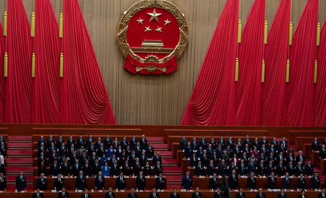Delegates including Chinese President Xi Jinping, center, stand as the national anthem is sung during the closing session of the National People's Congress (NPC) at the Great Hall of the People in Beijing, Thursday, March 12, 2026. (AP Photo/Ng Han Guan)