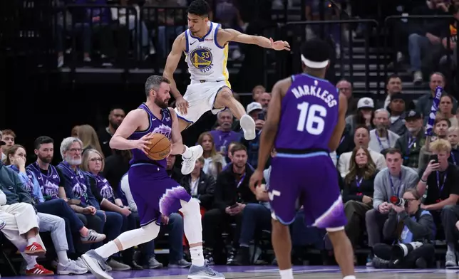 Utah Jazz forward Kevin Love, left, is fouled by Golden State Warriors forward Malevy Leons (33) while going up for a 3-point shot during the second half of an NBA basketball game, Monday, March 9, 2026, in Salt Lake City. (AP Photo/Rob Gray)