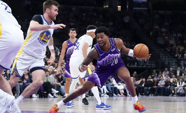Utah Jazz forward Brice Sensabaugh (28) steps back to shoot against Golden State Warriors guard Pat Spencer (61) during the first half of an NBA basketball game, Monday, March 9, 2026, in Salt Lake City. (AP Photo/Rob Gray)