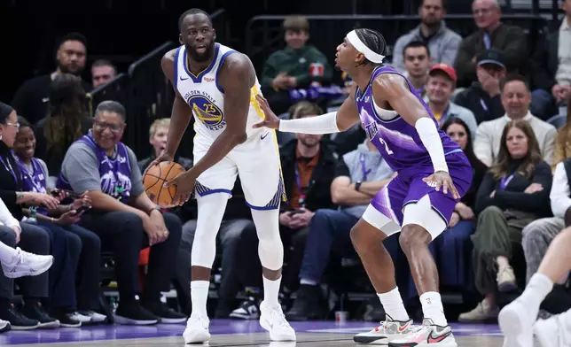 Golden State Warriors forward Draymond Green, left, looks for a play as Utah Jazz forward Blake Hinson (2) defends during the first half of an NBA basketball game, Monday, March 9, 2026, in Salt Lake City. (AP Photo/Rob Gray)