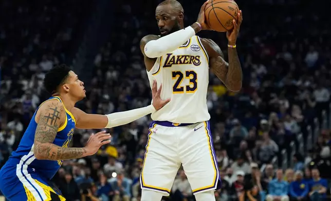 Los Angeles Lakers forward LeBron James (23) moves the ball while defended by Golden State Warriors guard Will Richard (3) during the first half of an NBA basketball game, Saturday, Feb. 28, 2026, in San Francisco. (AP Photo/Godofredo A. Vásquez)