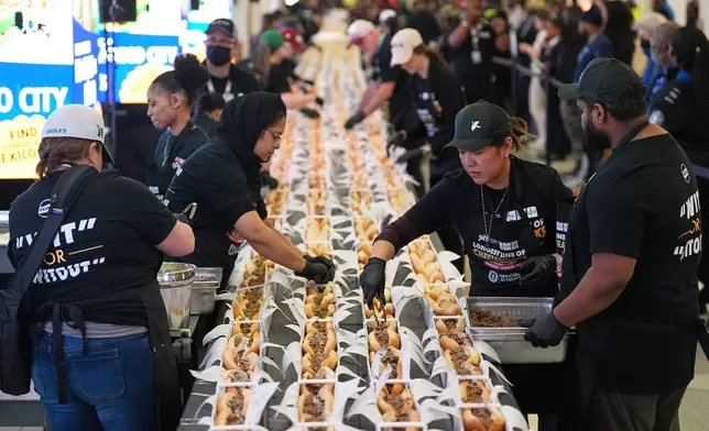 Volunteers assemble cheesesteaks in a Guinness World Record attempt on National Cheesesteak Day at Philadelphia International Airport, Tuesday, March 24, 2026, in Philadelphia. (AP Photo/Matt Rourke)