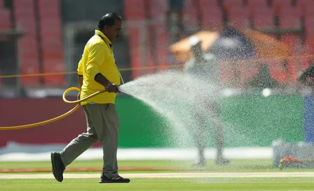 A groundsman sprays water on the pitch ahead of the T20 World Cup cricket final match between India and New Zealand in Ahmedabad, India, Saturday, March 7, 2026. (AP Photo/Ajit Solanki)