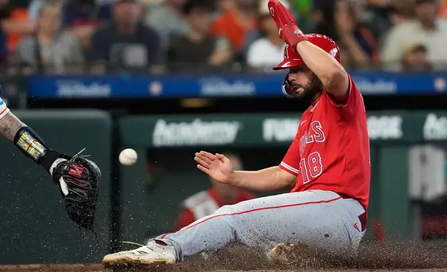 Los Angeles Angels' Nolan Schanuel scores ahead of a throw to Houston Astros catcher Christian Vazquez during the third inning of a baseball game in Houston, Sunday, March 29, 2026. (AP Photo/Ashley Landis)