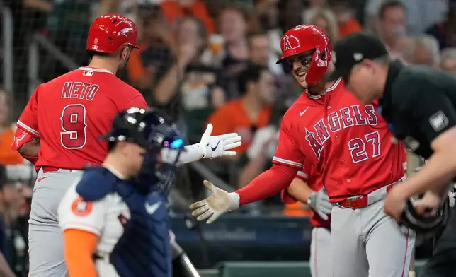 Los Angeles Angels' Zach Neto (9) celebrates with designated hitter Mike Trout (27) after hitting a home run during the fourth inning of a baseball game against the Houston Astros in Houston, Sunday, March 29, 2026. (AP Photo/Ashley Landis)