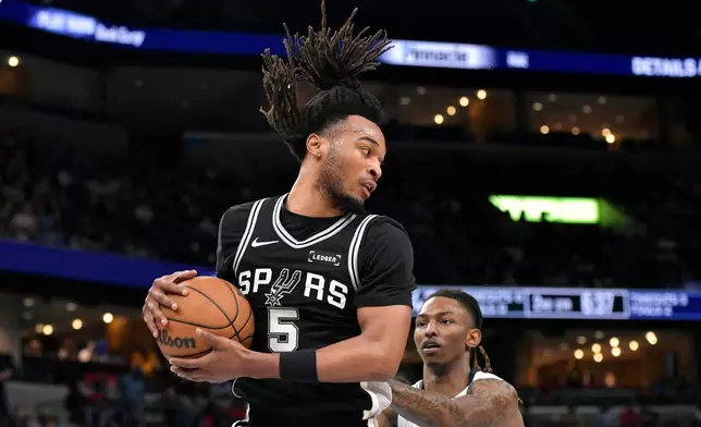 San Antonio Spurs guard Stephon Castle (5) handles the ball against Memphis Grizzlies guard Javon Small in the first half of an NBA basketball game Wednesday, March 25, 2026, in Memphis, Tenn. (AP Photo/Brandon Dill)