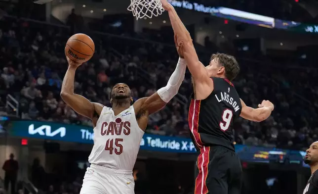 Cleveland Cavaliers guard Donovan Mitchell goes up for a shot next to Miami Heat guard Pelle Larsson (9) in the first half of an NBA basketball game in Cleveland, Wednesday, March 25, 2026. (AP Photo/Sue Ogrocki)