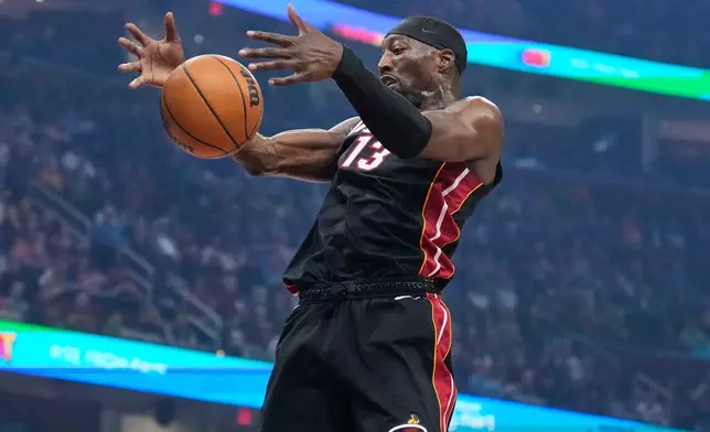Miami Heat center Bam Adebayo (13) grabs a rebound in the first half of an NBA basketball game against the Cleveland Cavaliers in Cleveland, Wednesday, March 25, 2026. (AP Photo/Sue Ogrocki)
