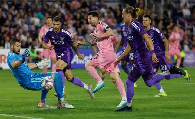 Inter Miami CF forward Lionel Messi, center, is surrounded by Orlando City SC players as he tries to score a goal during the first half of an MLS soccer match, Sunday, March 1, 2026, in Orlando, Fla. (AP Photo/Kevin Kolczynski)