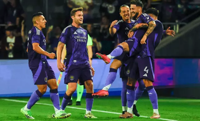 Orlando City SC forward Marco Pasalic, right, is lifted inn the air as he celebrates with team mates after scoring first goal against Inter Miami CF during the first half of an MLS soccer match, Sunday, March 1, 2026, in Orlando, Fla. (AP Photo/Kevin Kolczynski)