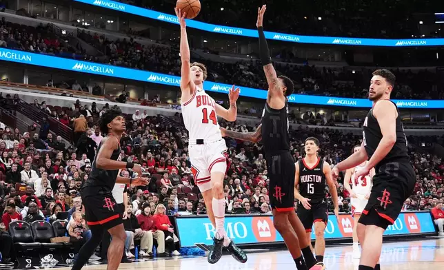 Chicago Bulls forward Matas Buzelis (14) drives to the basket against Houston Rockets forward Jabari Smith Jr., center right, during the first half of an NBA basketball game in Chicago, Monday, March 23, 2026. (AP Photo/Nam Y. Huh)