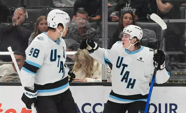 Utah Mammoth center Logan Cooley (92) celebrates his goal with defenseman Mikhail Sergachev (98) during the first period of an NHL hockey game Saturday, March 28, 2026, in Los Angeles. (AP Photo/Jae C. Hong)