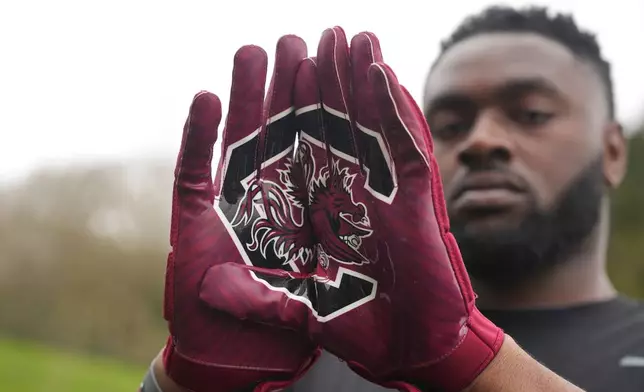 Oluwanifemi 'Neff' Giwa wears South Carolina 'Gamecocks" gloves as he takes part in a football workout session at the National Sports Center, Crystal Palace in London, Sunday, March 29, 2026. (AP Photo/Alastair Grant)