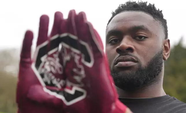 Oluwanifemi 'Neff' Giwa wears South Carolina 'Gamecocks" gloves as he takes part in a football workout session at the National Sports Center, Crystal Palace in London, Sunday, March 29, 2026. (AP Photo/Alastair Grant)